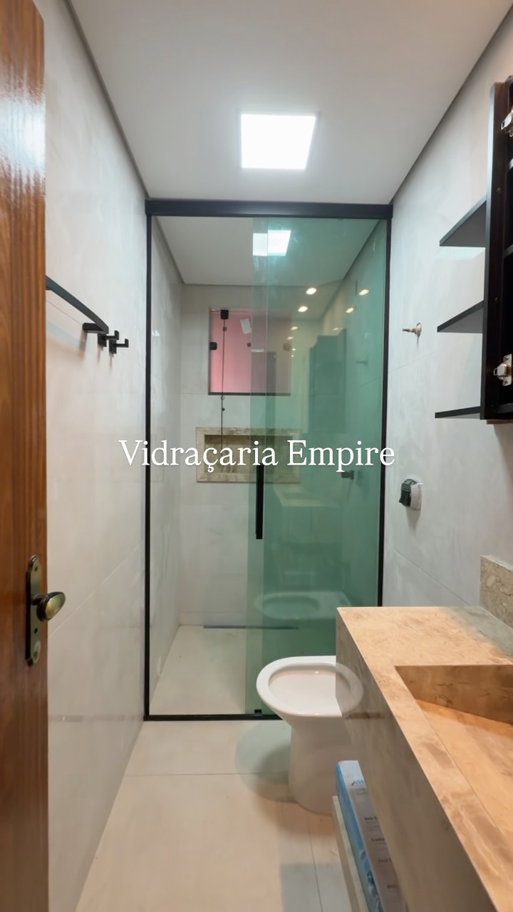Box de banheiro em vidro verde-esfumaçado com bancada de granito