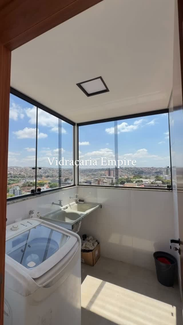 Fechamento envidraçado de canto em área de serviço com vista da cidade
